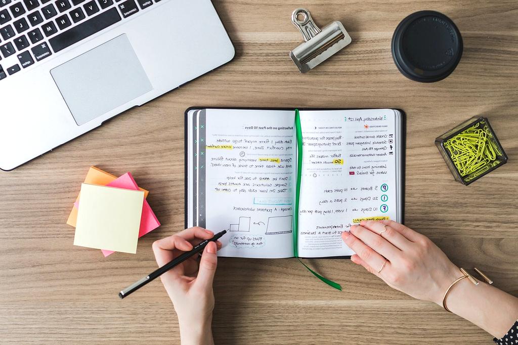 Modern organized workspace with laptop, notebook and planning tools